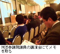 写真：舛添参議院議員の講演会にてメモを取る