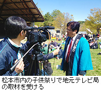写真：松本市内の子供祭りで地元テレビ局の取材を受ける