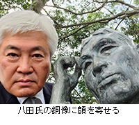 写真：八田氏の銅像に顔を寄せる